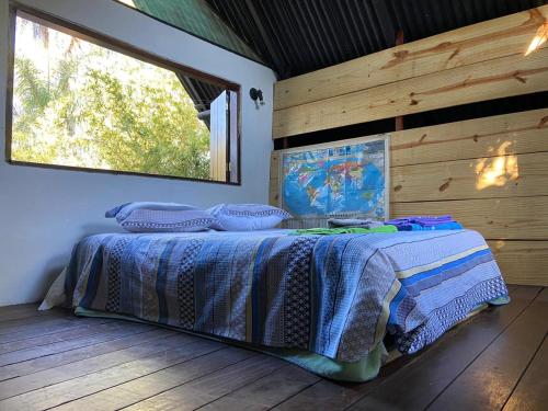 ein Schlafzimmer mit einem Bett in einem Zimmer mit einem Fenster in der Unterkunft Sinta-se em casa in Alto Paraíso de Goiás