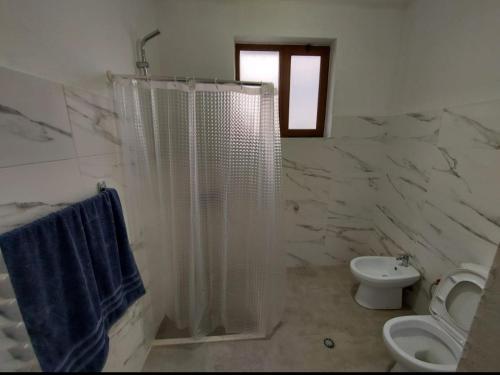 a bathroom with a shower and a toilet and a sink at Your Home Away from Home in Shkodër
