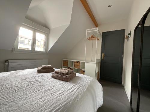 a bedroom with a bed with two towels on it at Chambres d'hôtes à 30 min de Paris in Maisons-Laffitte
