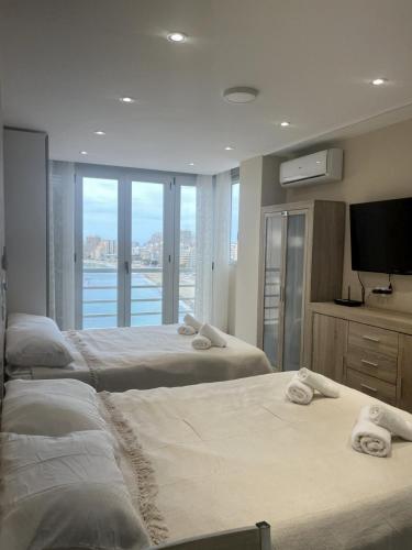 a bedroom with three beds with towels on them at Pequeno paraiso in Ifach