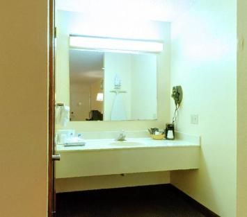 a bathroom with a sink and a large mirror at Americas Best Value Inn - Malvern in Malvern