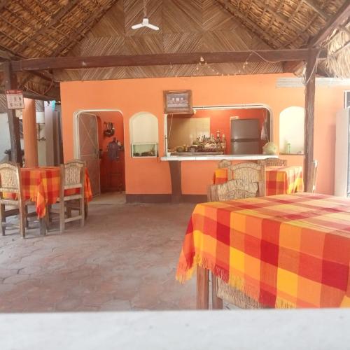 a room with a table and chairs and a kitchen at Bungalow confortable en lagunas de Chacahua in La Sabrosa