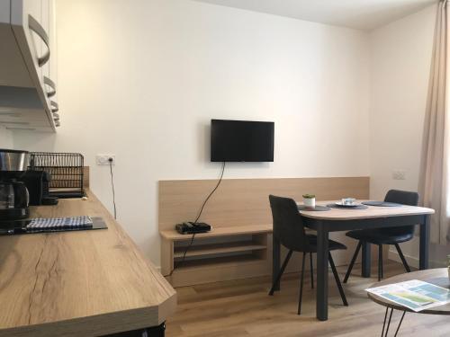 Cette chambre dispose d'une table et d'une télévision murale. dans l'établissement LE LARBAUD - Hypercentre - Clim - Thermes- RDC, à Vichy