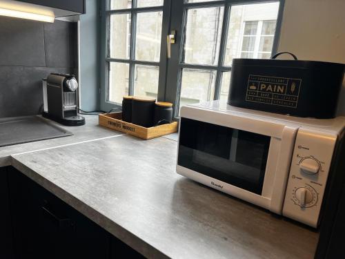 d'un four micro-ondes avec une boîte sur un comptoir. dans l'établissement Appartement hyper centre de Valenciennes, à Valenciennes