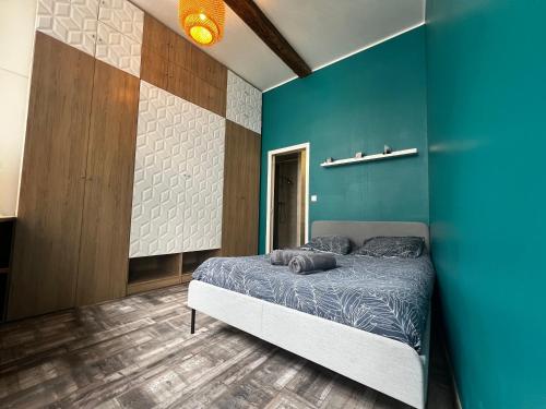 a bedroom with a blue wall and a bed at Appartement hyper centre de Valenciennes in Valenciennes