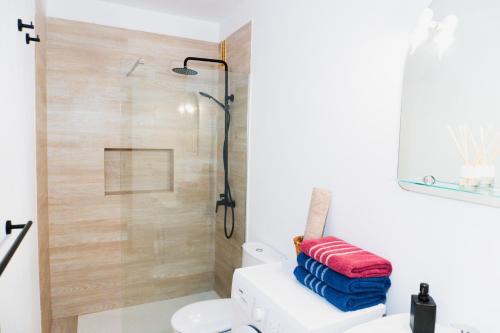 a bathroom with a shower and a toilet and towels at Casa Lago Azul 49 in Los Cancajos
