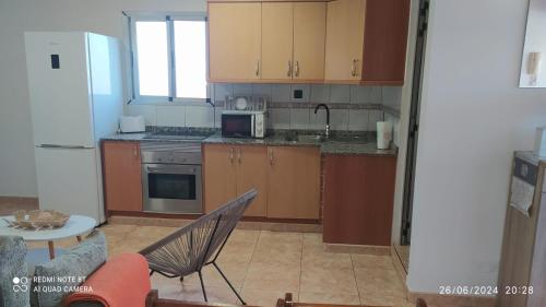 a kitchen with brown cabinets and a white refrigerator at Garza Attic House in Ojos de Garza