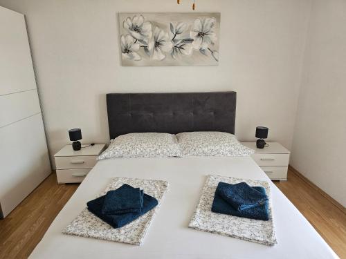 a bedroom with a white bed with two pillows on it at Apartment Ivan in Tribunj