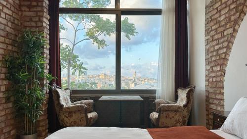 a room with two chairs and a large window at The Haliç Bosphorus Hotel in Istanbul
