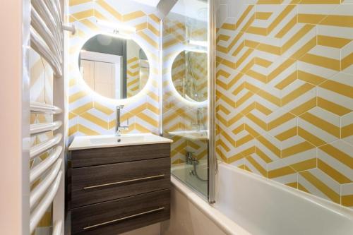 une salle de bain avec un lavabo et un miroir dans l'établissement Résidence Les Brigues - maeva Home - Appartement 2 Pièces 6 Personnes - Sélection MAE-4708, à Courchevel