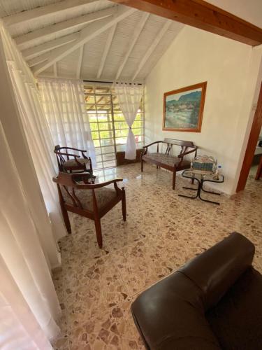 a living room with two chairs and a couch at Villa Ligia in Medellín