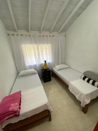 two beds in a room with a window at Villa Ligia in Medellín