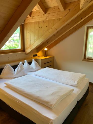 une chambre avec un grand lit blanc dans un grenier dans l'établissement Villa sulla passeggiata, à Ortisei