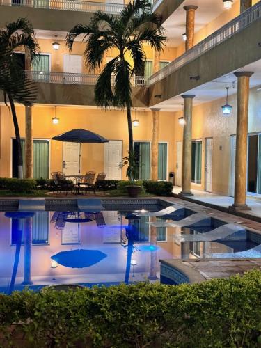 a swimming pool with a palm tree in a building at MESÓN DE LA RIVERA in San Juan Bautista Tuxtepec