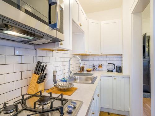 a kitchen with white cabinets and a sink at Highfall Hideaway Your Cozy Escapewi-fitvpets in Rochester