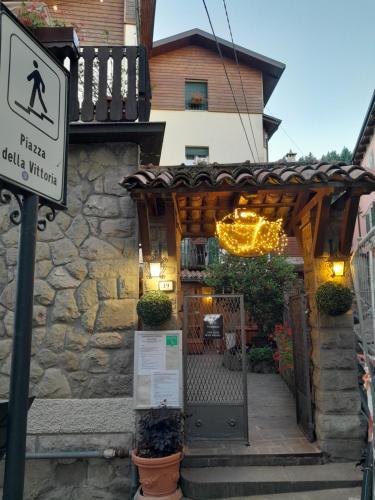 a entrance to a house with a wooden pergola at Hotel Regina Yeti Bistrot in Sestola
