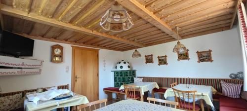 un comedor con 2 mesas y un reloj en la pared en Haus Adler, en Gröbming