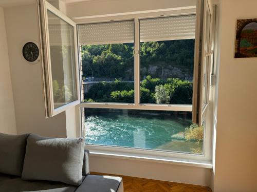 a window with a view of a swimming pool through it at Stan na dan Foca in Foča