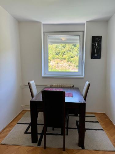 a dining room table with chairs and a window at Stan na dan Foca in Foča