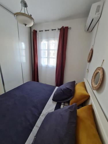 a bedroom with a blue bed and a window at Maison d'été hessi Jerbi ras marmour in Zarzis