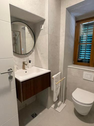 a bathroom with a sink and a toilet and a mirror at Old town Pjaca Makarska in Makarska