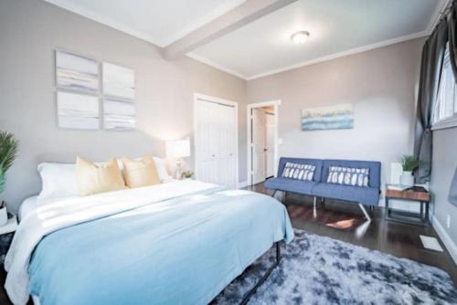 a bedroom with a large white bed and a blue bench at Chic 1BR Retreat with Sofa Bed, Free Parking in Indianapolis