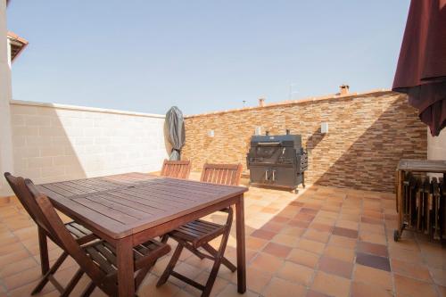 a wooden table and chairs on a patio with a grill at Las Natillas con V in Martín Miguel