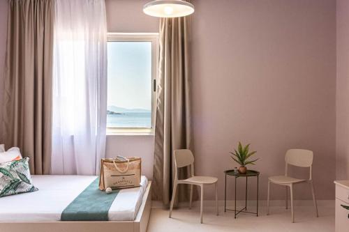 a bedroom with a bed and a window with chairs at Himara City 24 - Central & Beach Access in Himare