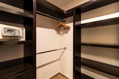 a walk in closet with black shelves and a microwave at Grand Chapultepec Residencial in Mexico City