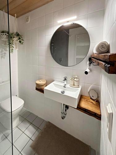 a white bathroom with a sink and a mirror at Der Eulenschlupf in Ühlingen-Birkendorf