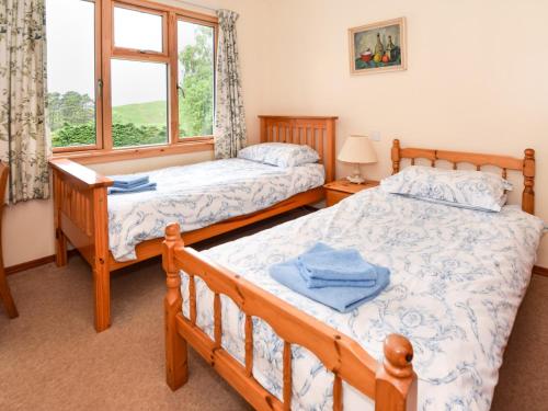 zwei Betten in einem Schlafzimmer mit Fenster in der Unterkunft 5 Bed in Roshven CA231 in Glenuig