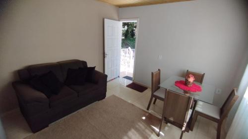 ein Wohnzimmer mit einem Sofa und einem Tisch mit einer Puppe darauf in der Unterkunft APARTAMENTO DU VÔ - Cantinho Du Vô in Santa Teresa