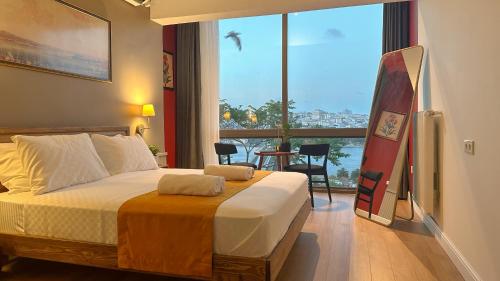 a bedroom with a bed and a large window with a surfboard at The Haliç Bosphorus Hotel in Istanbul