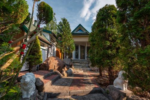 a house with some statues in front of it at Zacisze Zygmuntowo in Zygmuntowo