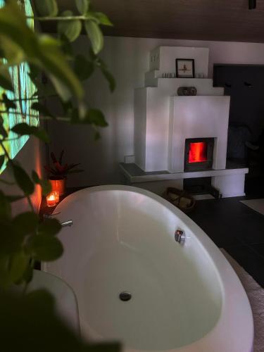a white bath tub in a room with a fireplace at Der Eulenschlupf in Ühlingen-Birkendorf