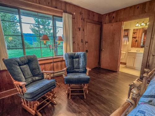 a bedroom with two chairs and a bed and a window at Hemlock Inn in Bryson City