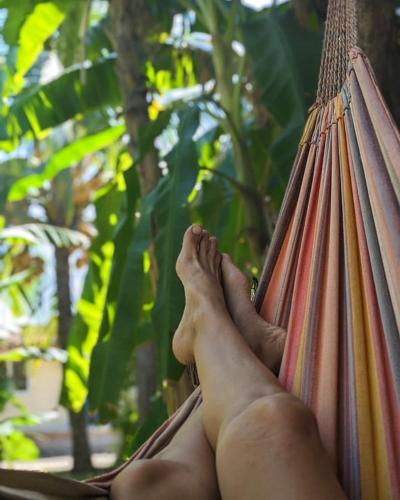 a person sitting in a hammock with their feet up at Nuevo NAYAL in Las Peñitas