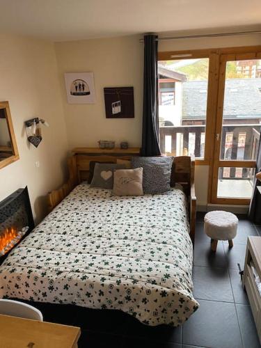 - une chambre avec un lit dans une pièce dotée d'une cheminée dans l'établissement La Plagne, Montchavin, les Coches, à La Plagne Tarentaise