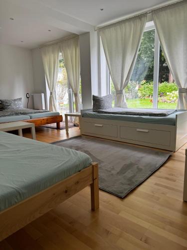 a bedroom with two beds and a large window at Gemütliches Gasthaus in Pinneberg