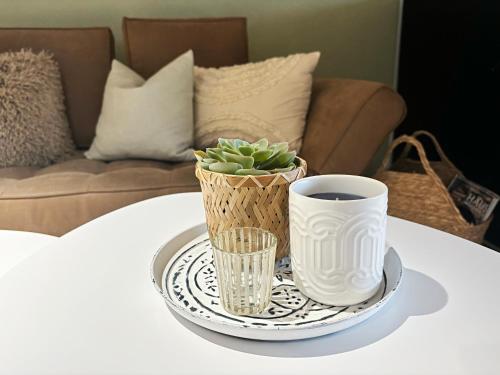 a tray with a cup of coffee and a plant on a table at Der Eulenschlupf in Ühlingen-Birkendorf