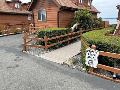 a sign on a wooden fence in front of a house at Sand Castle - Ocean Cabin 25 W Private Jacuzzi in Smith River