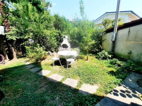 a garden with a table and chairs in the grass at Ampie camere Locarno in Locarno