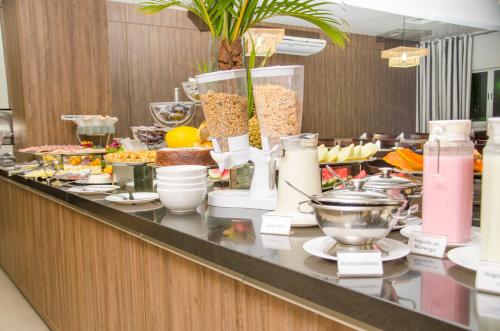 ein Buffet mit Essen in einem Hotelzimmer in der Unterkunft Camboa Hotel Paranaguá in Paranaguá