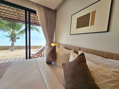 a bedroom with a bed with a view of the beach at Boon Heritage House Koh Samui in Koh Samui