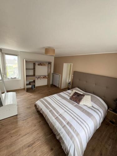 une chambre avec un grand lit dans une pièce dans l'établissement Gîte le Lavoir, à Oger