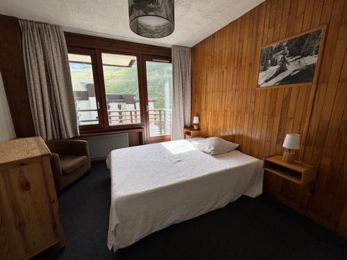 une chambre avec un lit, une chaise et une fenêtre dans l'établissement Spacieux 3 pièces avec balcon, coeur des commerces à Tignes - FR-1-449-22, à Tignes