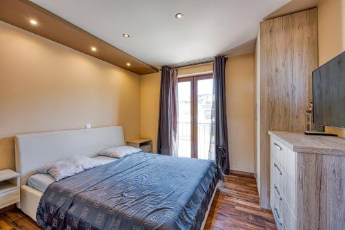 a bedroom with a bed and a large window at Apartment M- Panoramic View in Mugeba
