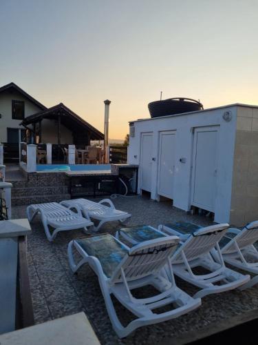 a group of chaise lounges and chairs on a patio at Pensiunea agroturistica Casa Sirca in Boghiş