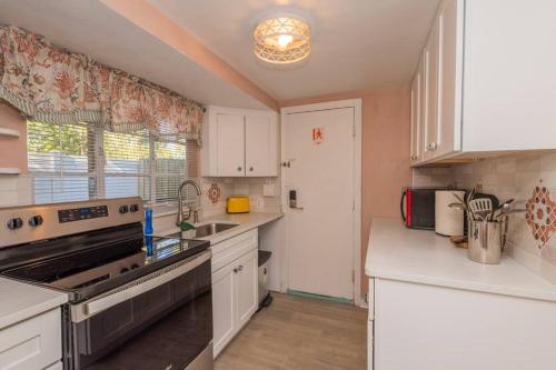 a kitchen with white cabinets and a stove top oven at 2BR at Lecom Park Downtown Beaches & Ample Parking Space in Bradenton