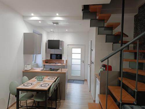 une cuisine et une salle à manger avec une table et un escalier dans l'établissement Aux nids douillets Mayetois 